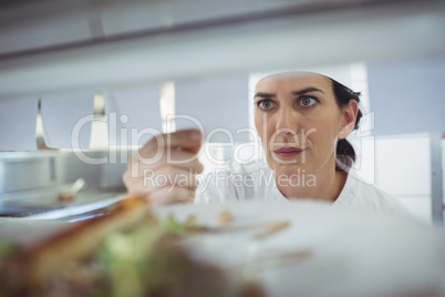 Female chef looking at an order list in the commercial kitchen