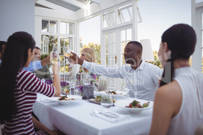Group of friends toasting glasses of wine during lunch