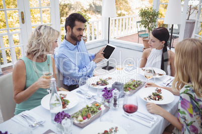 Group of friends interacting with each other while having meal together