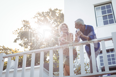 Smiling couple having champagne in balcony
