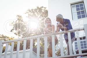 Smiling couple having champagne in balcony
