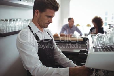 Waiter making coffee at counter