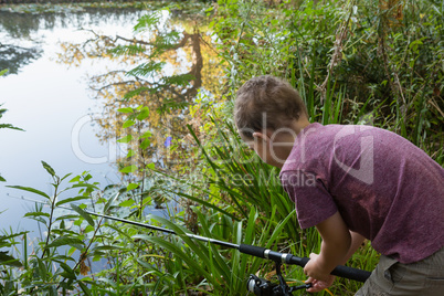 Boy fishing in the river in forest