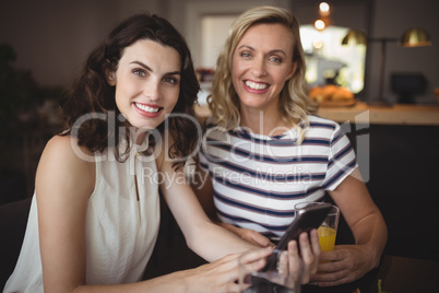 Portrait of two young women using mobile phone