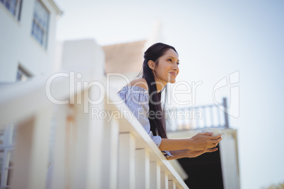 Thoughtful young woman holding a coffee cup