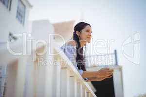 Thoughtful young woman holding a coffee cup