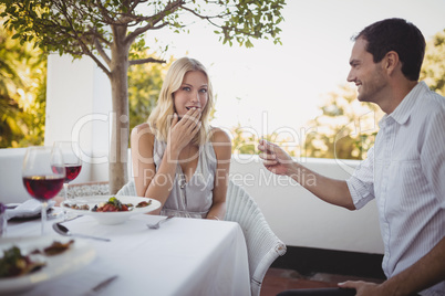 Man offering engagement ring to surprised woman