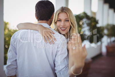 Happy woman showing engagement ring