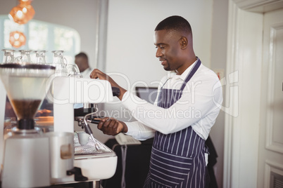 Waiter preparing espresso at restaurant