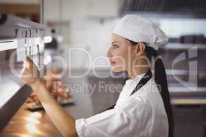 Female chef looking at an order list in the commercial kitchen
