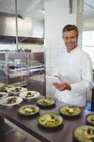 Portrait of male chef using digital tablet at order station