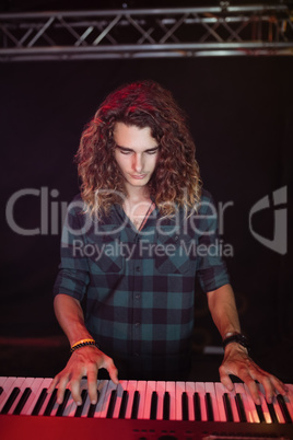 Young male musician playing piano at nightclub