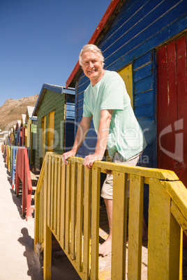 Portrait of smiling senior man standing at beach house