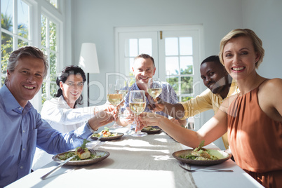 Group of happy friends toasting glasses of wine