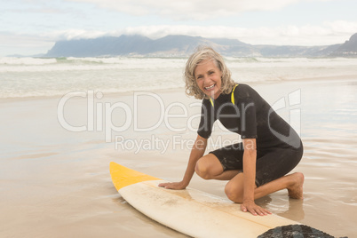 Portrait of smiling senior woman preparing for surfboarding