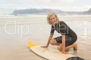 Portrait of smiling senior woman preparing for surfboarding