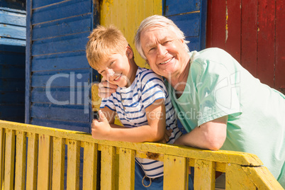 Portrait of happy grandfather and grandson leaning on railing