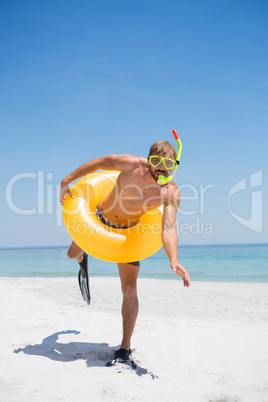 Playful man with snorkel wearing inflatable ring