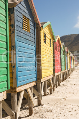 Close up of wooden huts on sand against clear sky