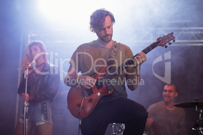 Male guitarist perfoming with guitar during music festival