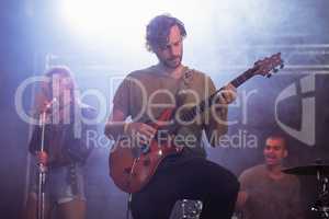 Male guitarist perfoming with guitar during music festival