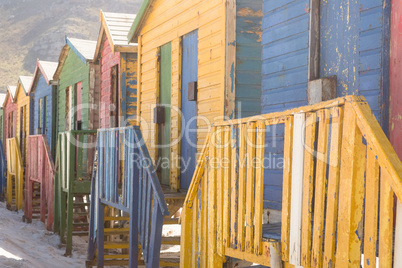 Close up of multi colored wooden huts on sand