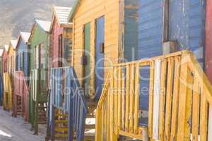 Close up of multi colored wooden huts on sand