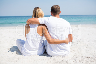 Rear view of couple relaxing at beach