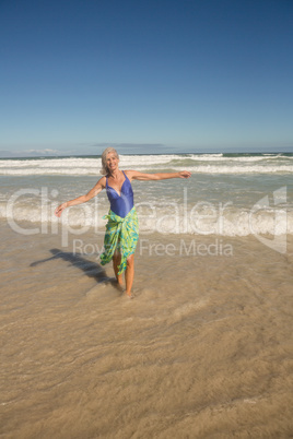 Portrait of smiling woman walking on shore