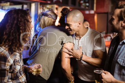 Smiling friends embracing at nightclub