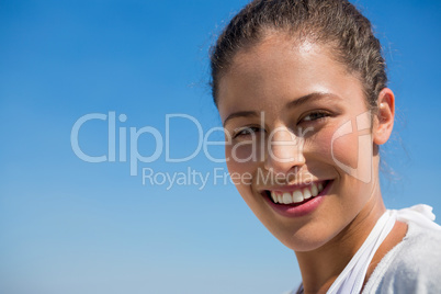 Close up portrait of smiling woman against blue sky