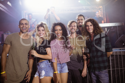 Portrait of cheerful friends standing at nightclub