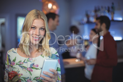 Beautiful woman using mobile phone at bar restaurant