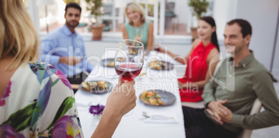 Group of friends interacting with each other while having meal together