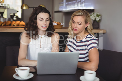 Friends using laptop at table