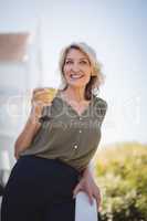 Smiling mature woman holding a glass of juice
