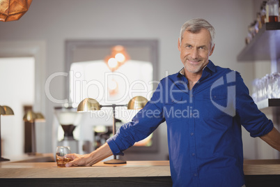 Portrait of mature man standing at counter