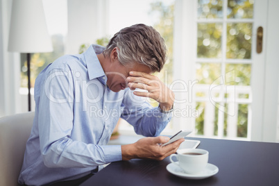 Businessman with head in hand in restaurant