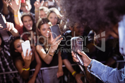 Fans photographing singer performing at nightclub