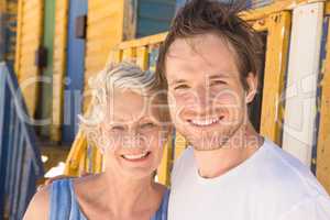 Smiling man with mother standing against beach hut