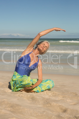 Close up of woman practising yoga while sitting on sand