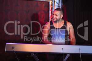 Happy musician playing piano at nightclub