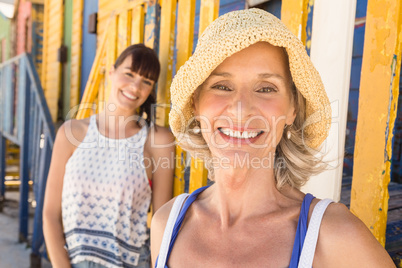 Portrait of happy mother and daughter standing against wall