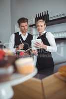 Waiters using digital tablet at counter