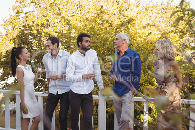 Friends interacting with each other while having champagne in balcony