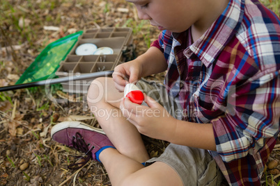 Boy preparing a bait in the forest