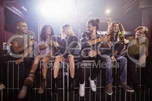 Happy friends toasting beer bottles