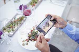 Man taking picture of food from mobile phone