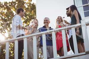 Friends interacting while having champagne in balcony