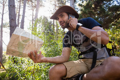 Man talking on the mobile phone while holding the map